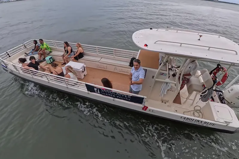 Slide: The Image of Boat tour with passengers on a 2023 Henriksen Design Group vessel, cruising on calm waters. - 4