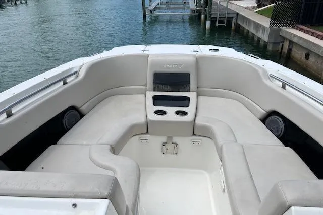Slide: The Image of 2015 Boston Whaler 270 Vantage boat interior with cushioned seating and cup holders. - 10