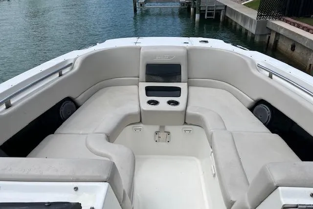 Slide: The Image of 2015 Boston Whaler 270 Vantage boat interior with cushioned seating and cup holders. - 11