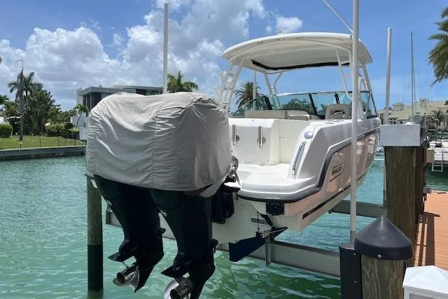 Slide: The Image of 2015 Boston Whaler 270 Vantage boat docked, featuring dual outboard motors. - 17