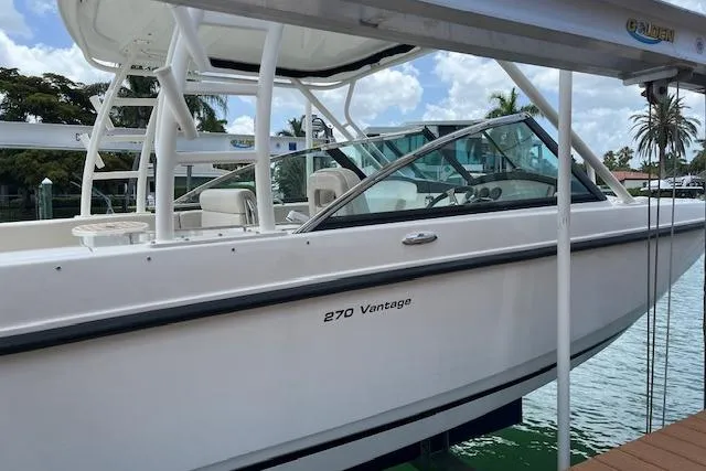 Slide: The Image of 2015 Boston Whaler 270 Vantage boat docked by the water. - 2