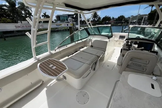 Slide: The Image of 2015 Boston Whaler 270 Vantage boat interior with seating and helm, docked by the water. - 21