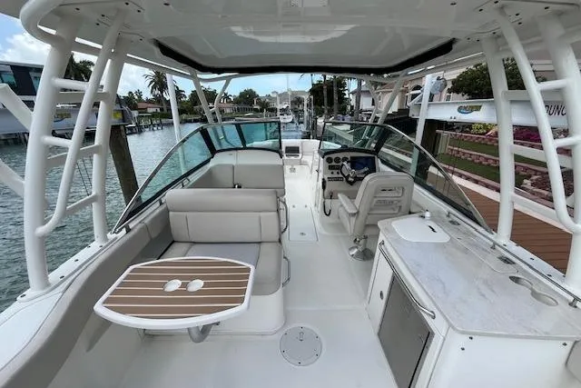 Slide: The Image of 2015 Boston Whaler 270 Vantage boat interior with seating, table, and helm station. - 24