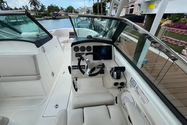 Slide: The Image of 2015 Boston Whaler 270 Vantage boat cockpit with steering wheel and control panel. - 25