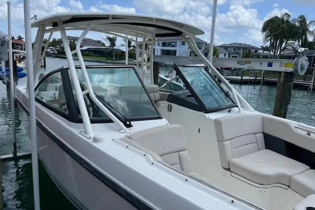 Slide: The Image of 2015 Boston Whaler 270 Vantage boat docked in a marina under a partly cloudy sky. - 4
