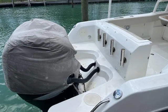 Slide: The Image of 2015 Boston Whaler 270 Vantage boat stern with covered outboard motor in marina. - 6
