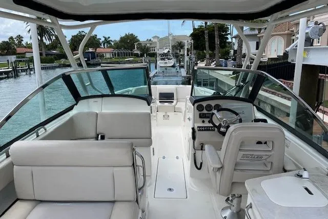 Slide: The Image of 2015 Boston Whaler 270 Vantage boat interior with helm, seating, and waterfront view. - 7