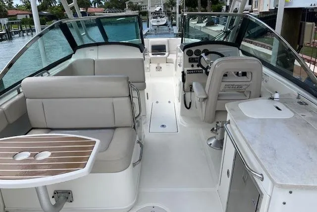 Slide: The Image of 2015 Boston Whaler 270 Vantage interior with seating, helm, and kitchenette. - 8
