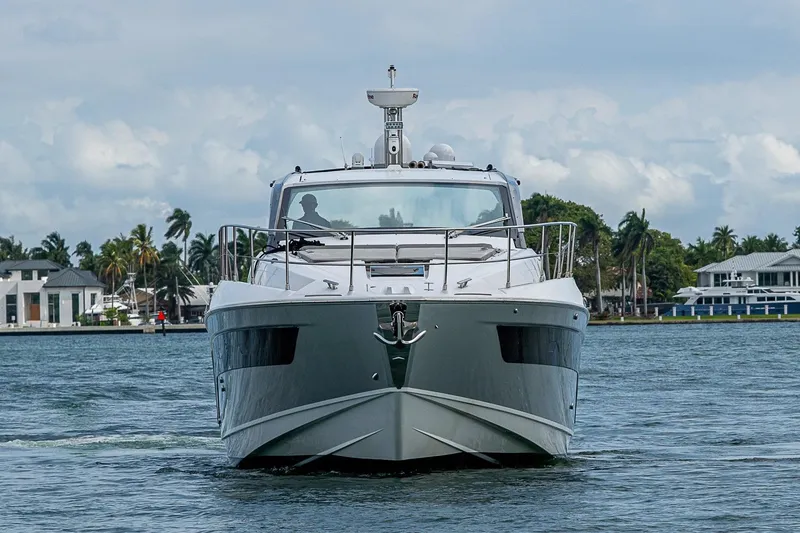 Slide: The Image of 2019 Azimut Atlantis 51 yacht cruising on a scenic waterway with palm trees in the background. - 4