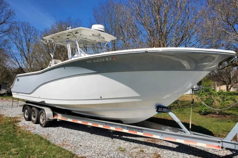 Slide: The Image of 2019 Sea Fox 328 Commander boat on trailer, parked outdoors on gravel. - 2