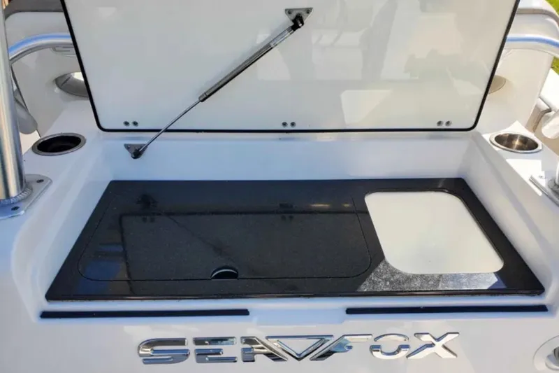 Slide: The Image of 2019 Sea Fox 328 Commander boat storage compartment with open lid and logo. - 7
