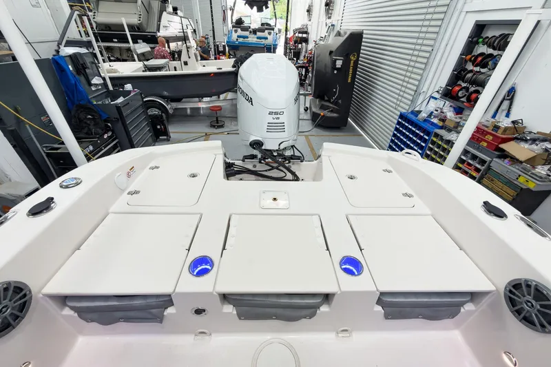 Slide: The Image of Carolina Skiff 24 Ultra Elite 2026 in workshop area with Honda engine. - 23