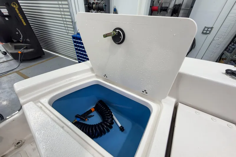 Slide: The Image of 2026 Carolina Skiff 24 Ultra Elite with storage compartment and hose. - 24