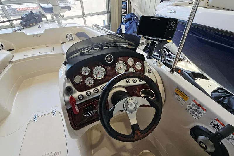 Slide: The Image of 2012 Tahoe 215 Xi boat dashboard with steering wheel and gauges. - 11