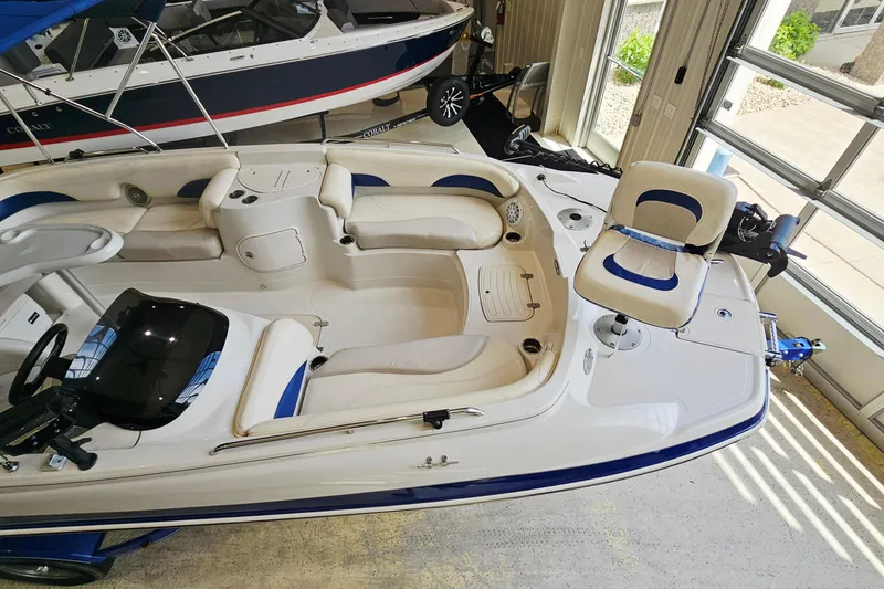 Slide: The Image of 2012 Tahoe 215 Xi boat interior with seating and steering, displayed indoors. - 14