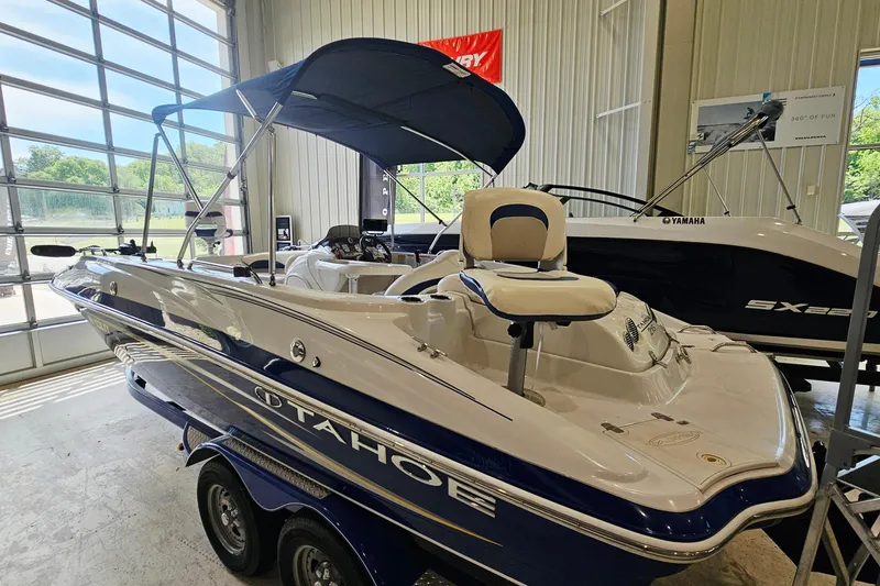 Slide: The Image of 2012 Tahoe 215 Xi boat with canopy in a showroom setting. - 3