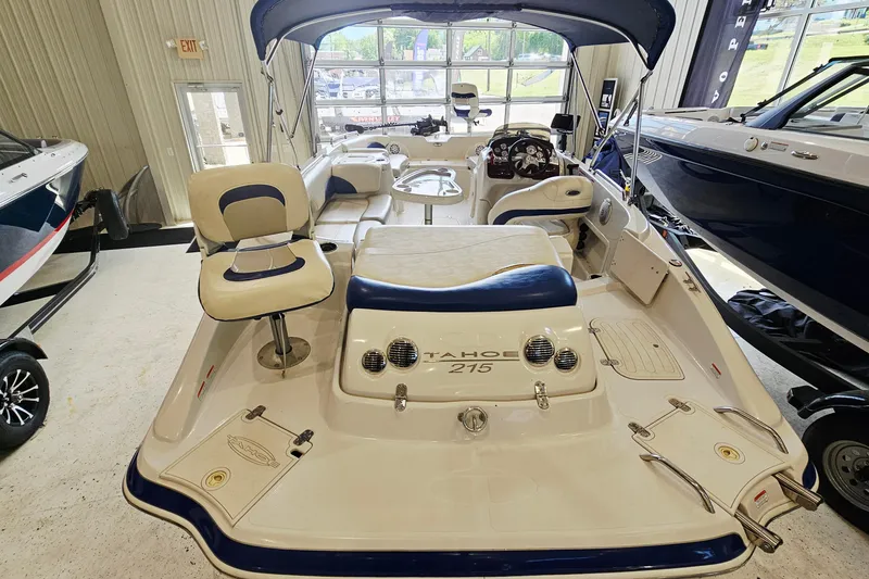 Slide: The Image of 2012 Tahoe 215 Xi boat interior with seating and steering, displayed indoors. - 5