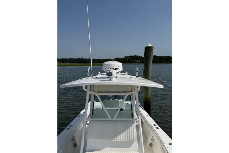 Slide: The Image of 2005 Regulator 32 Forward Seating boat docked on calm water. - 16
