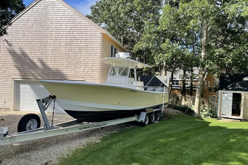 Slide: The Image of 2005 Regulator 32 Forward Seating boat on trailer beside house and trees. - 1