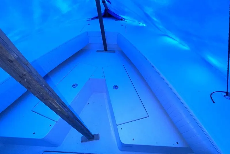 Slide: The Image of 2005 Regulator 32 Forward Seating boat interior under blue tarp. - 14