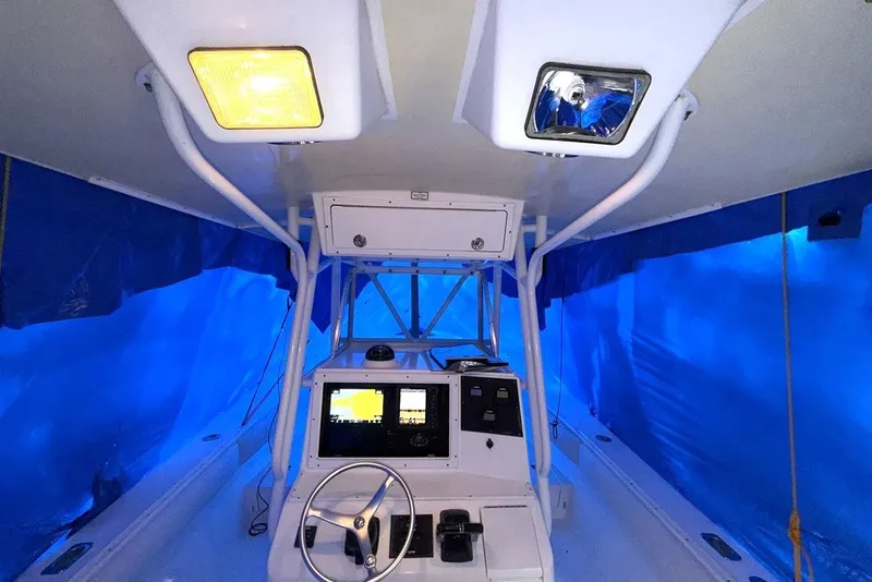 Slide: The Image of 2005 Regulator 32 Forward Seating boat interior with blue tarp covering. - 3