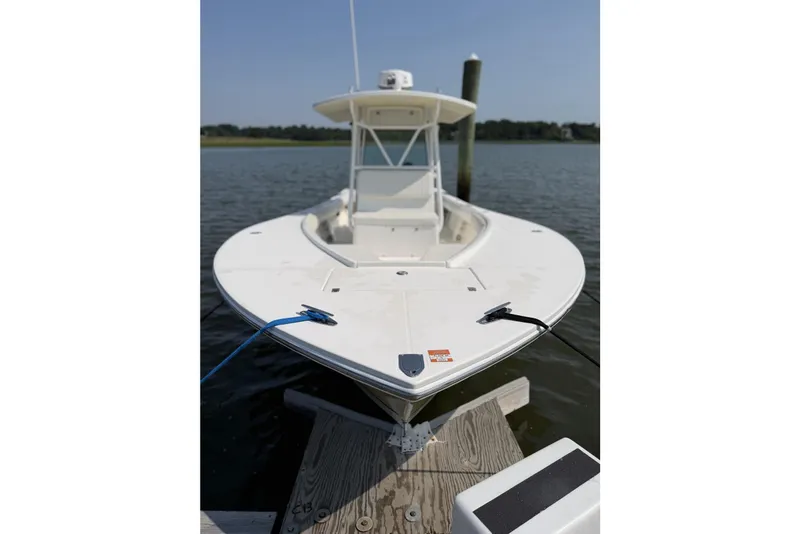 Slide: The Image of 2005 Regulator 32 Forward Seating boat docked on calm water. - 14
