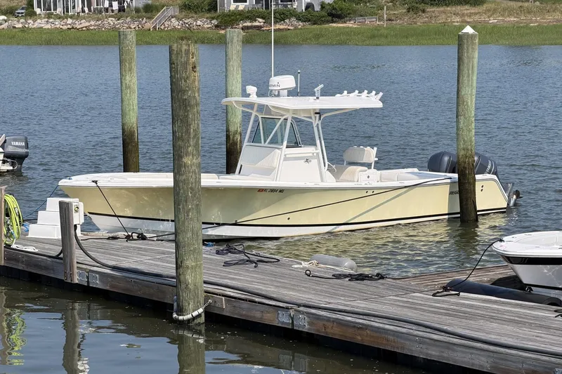 Slide: The Image of 2005 Regulator 32 Forward Seating boat docked on calm water. - 2