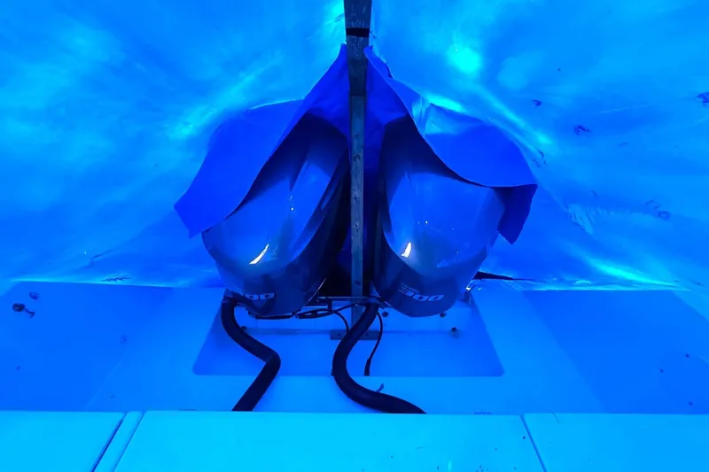 Slide: The Image of Covered outboard motors on a 2005 Regulator 32 Forward Seating boat under blue tarp. - 5