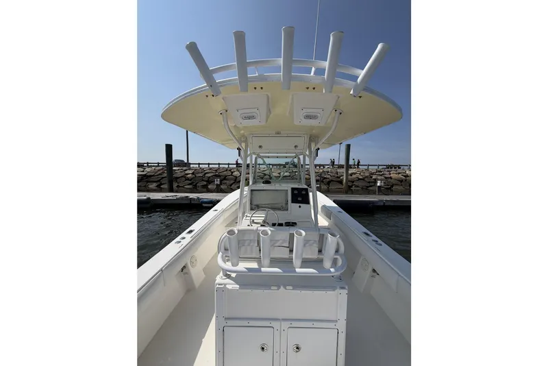 Slide: The Image of 2005 Regulator 32 Forward Seating boat at dock, featuring helm and rod holders. - 21