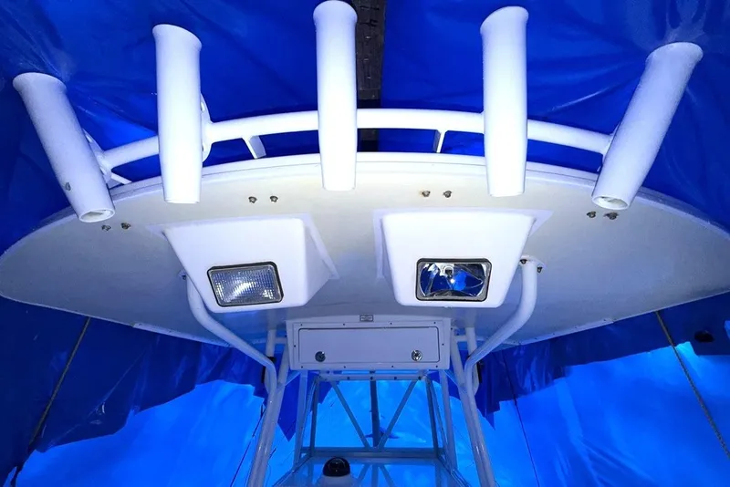 Slide: The Image of 2005 Regulator 32 Forward Seating boat with rod holders and lights under blue tarp. - 7