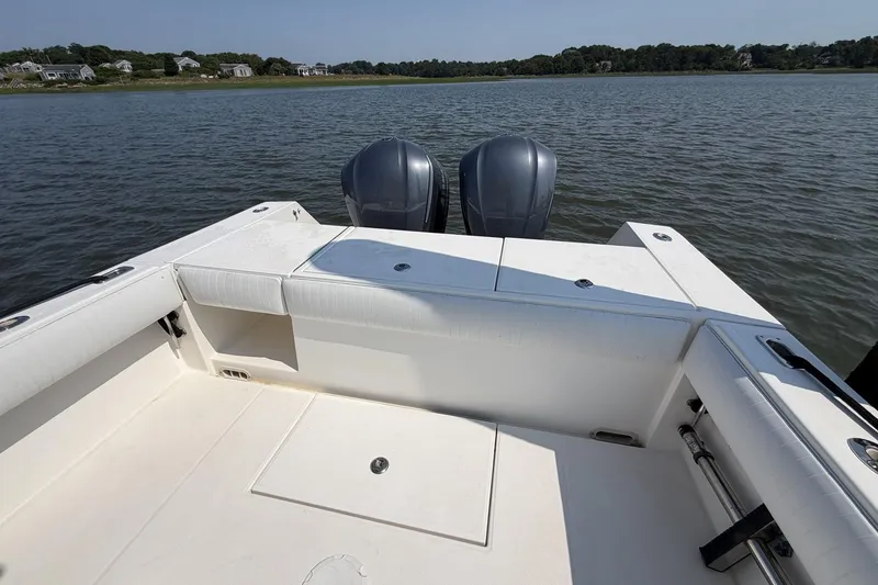 Slide: The Image of 2005 Regulator 32 Forward Seating boat on calm water, featuring dual outboard motors. - 20