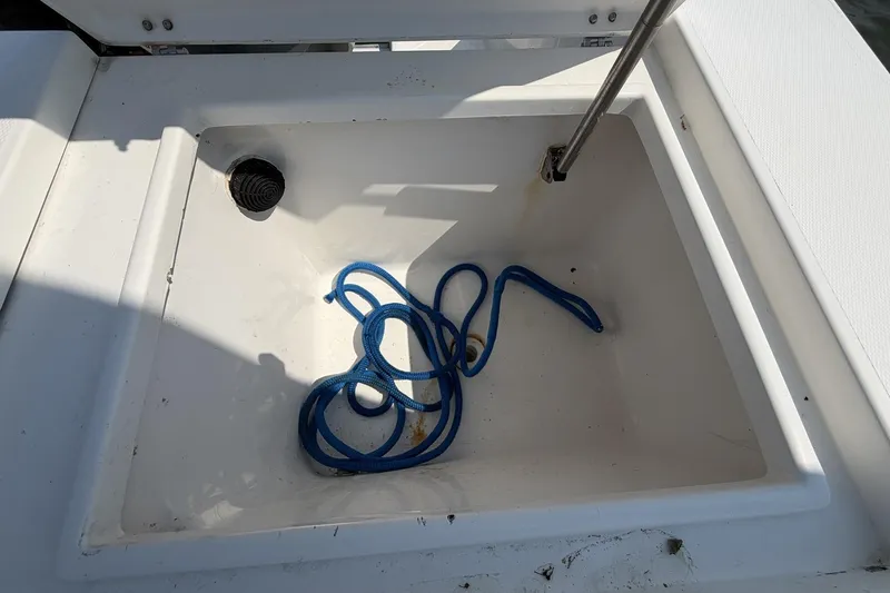 Slide: The Image of Open storage compartment with blue rope on a 2005 Regulator 32 Forward Seating boat. - 25