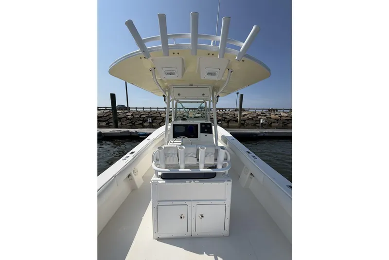 Slide: The Image of 2005 Regulator 32 Forward Seating boat with center console and rod holders at dock. - 26