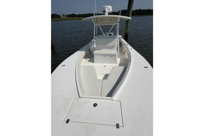 Slide: The Image of 2005 Regulator 32 Forward Seating boat on calm water, showcasing spacious deck and seating. - 15
