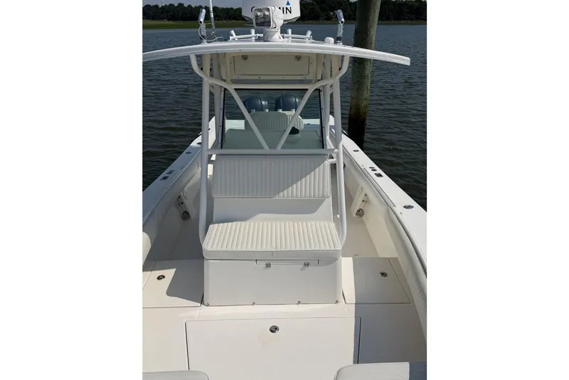 Slide: The Image of 2005 Regulator 32 Forward Seating boat with white seating and open deck on the water. - 17