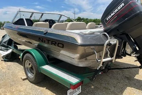 Slide: The Image of 1998 Tracker Targa 185 Sport boat on trailer with outboard motor, parked outdoors. - 5
