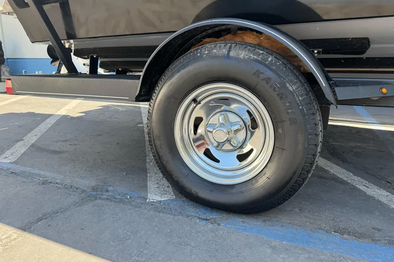 Slide: The Image of Trailer wheel of 2021 Tracker Pro Guide V-175 Combo in parking lot. - 3