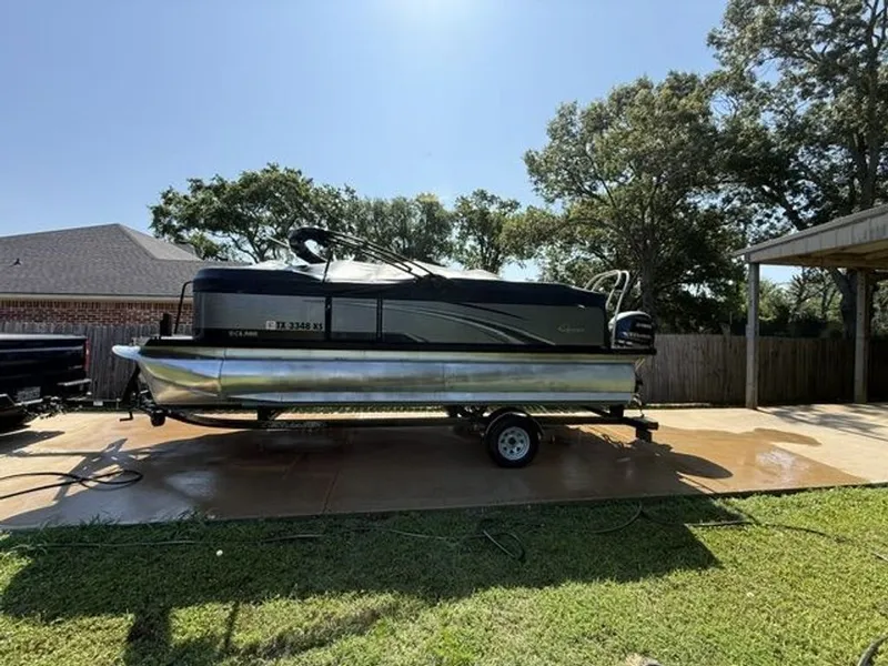 The Image of 2022 Quest Lanai pontoon boat parked on trailer outdoors. - 0