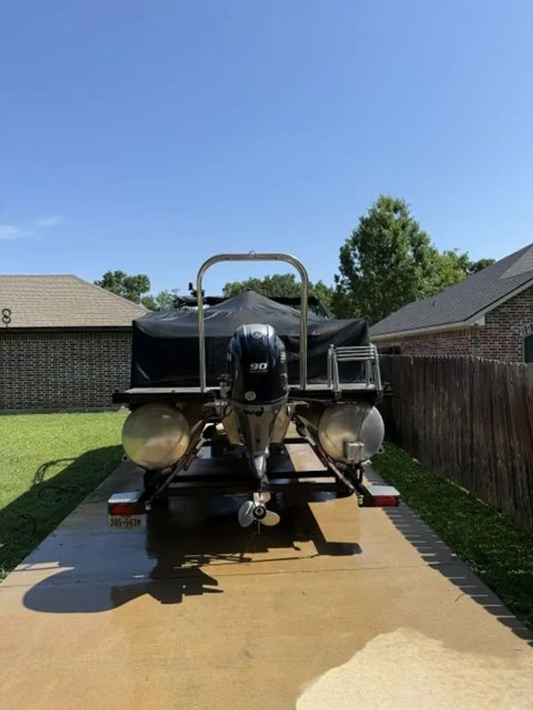 Slide: The Image of 2022 Quest Lanai boat on trailer in backyard. - 16