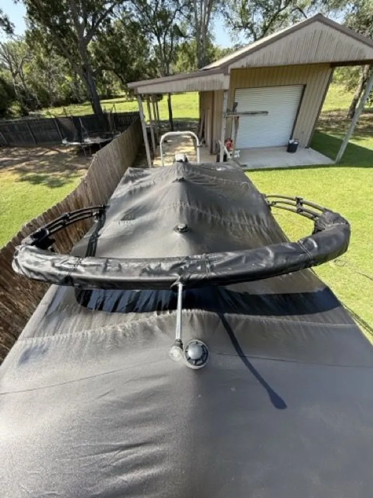 Slide: The Image of 2022 Quest Lanai with black cover, parked in a garden. - 25