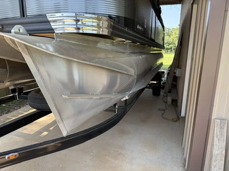 Slide: The Image of 2022 Quest Lanai pontoon boat parked in a garage. - 26