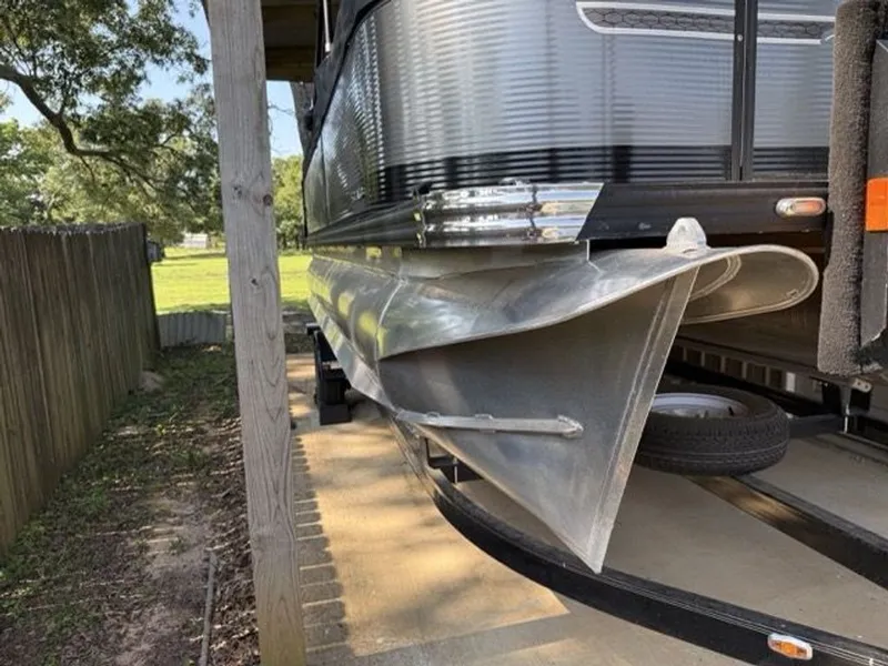 Slide: The Image of 2022 Quest Lanai pontoon boat parked on trailer. - 27