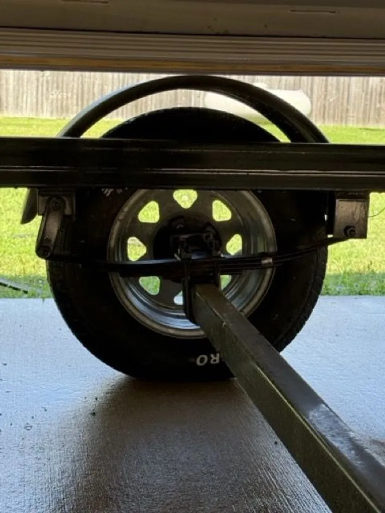 Slide: The Image of Close-up of a Quest Lanai 2022 trailer wheel on concrete. - 33