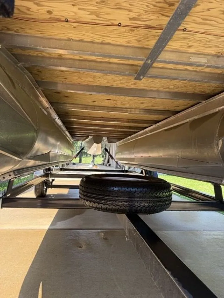 Slide: The Image of Underside of a 2022 Quest Lanai boat with spare tire. - 35