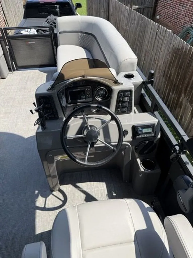 Slide: The Image of Interior of a 2022 Quest Lanai boat with steering console. - 5