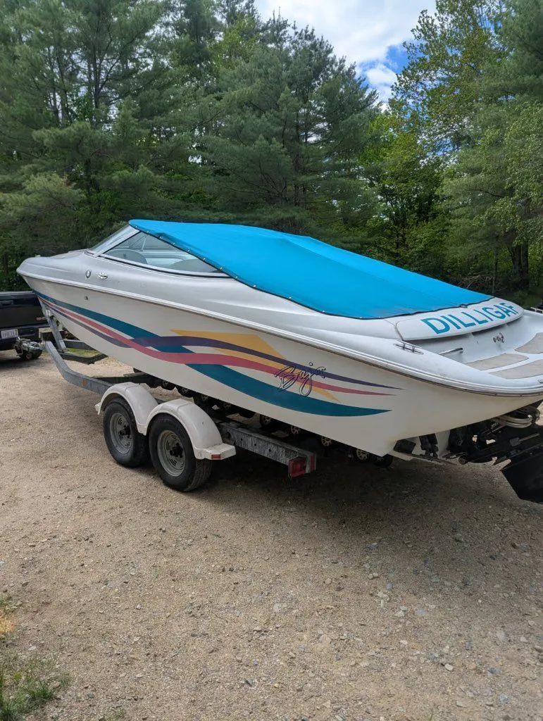 Slide: The Image of 1995 Baja 272 boat with blue cover on trailer. - 10