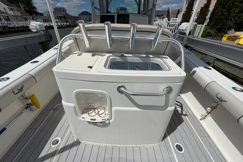 Slide: The Image of 2017 Mako 284 Center Console boat interior with fishing rod holders and storage. - 10
