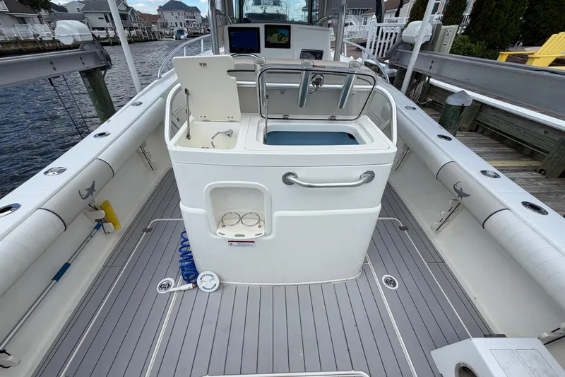 Slide: The Image of 2017 Mako 284 Center Console boat interior with fishing equipment and storage. - 11