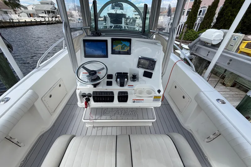 Slide: The Image of 2017 Mako 284 Center Console boat interior with navigation equipment and steering wheel. - 12