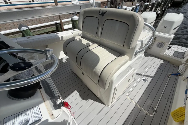 Slide: The Image of Interior of a 2017 Mako 284 Center Console boat with seating and steering wheel. - 13